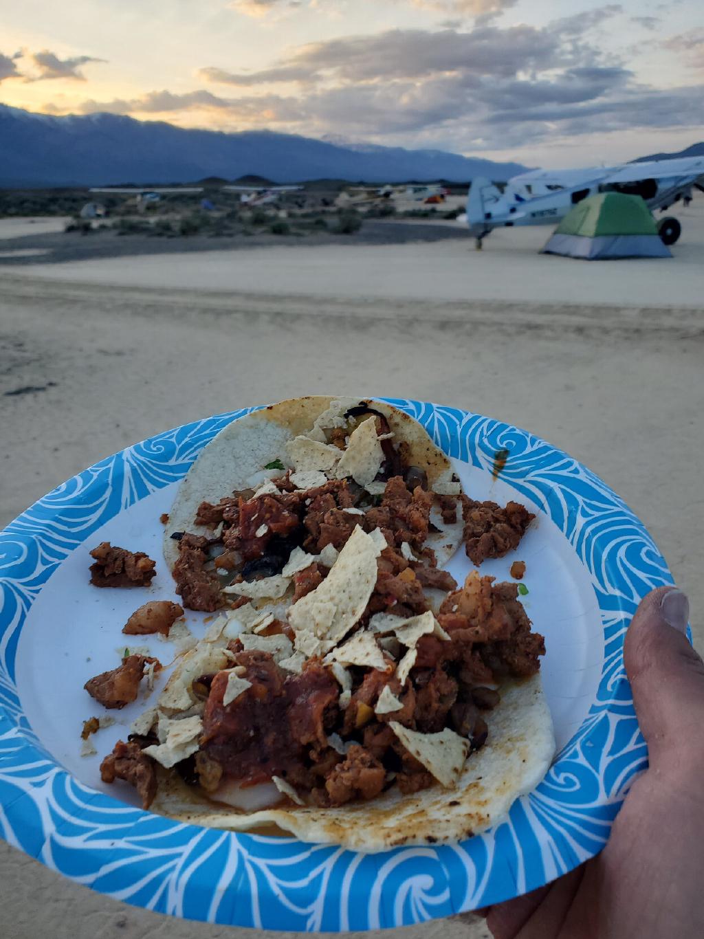 Desert Camp With Aircraft in the Background And